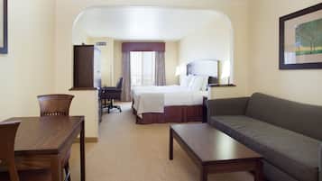Una habitación de hotel con cama, sofá, escritorio y una silla.