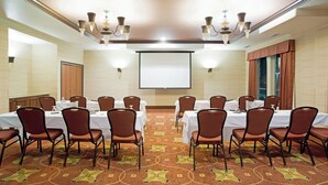 A conference room with tables, chairs, a projector screen, and chandeliers. - Holiday Inn Denver-Parker-E470/Parker Road by IHG (Parker)