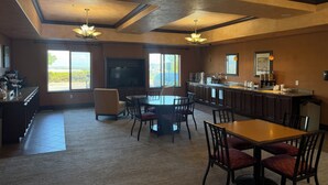 A spacious kitchen with a large island, a dining area with chairs, and a television. - Holiday Inn Denver-Parker-E470/Parker Road by IHG (Parker)
