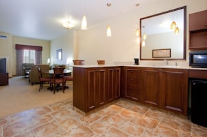 Una cocina moderna con armarios de madera, un espejo grande e iluminación colgante.