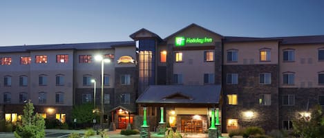 A Holiday Inn hotel with a central courtyard, multiple entry points, and a well-lit facade.