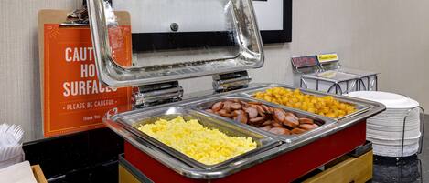 A buffet with scrambled eggs, sausage, and hash browns.