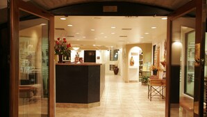 A hotel lobby with a reception desk, a gift shop, and a seating area. - Scottsdale Camelback Resort (Scottsdale)