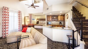 A spacious living area with a sofa, a dining table, and a kitchen area with a microwave and cabinets. - Scottsdale Camelback Resort (Scottsdale)