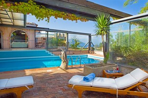 Una piscina al aire libre de temporada, sombrillas