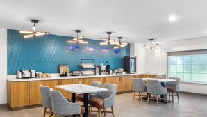 Un espace cuisine moderne avec un mur bleu à texture, des armoires en bois et un îlot central doté de sièges.