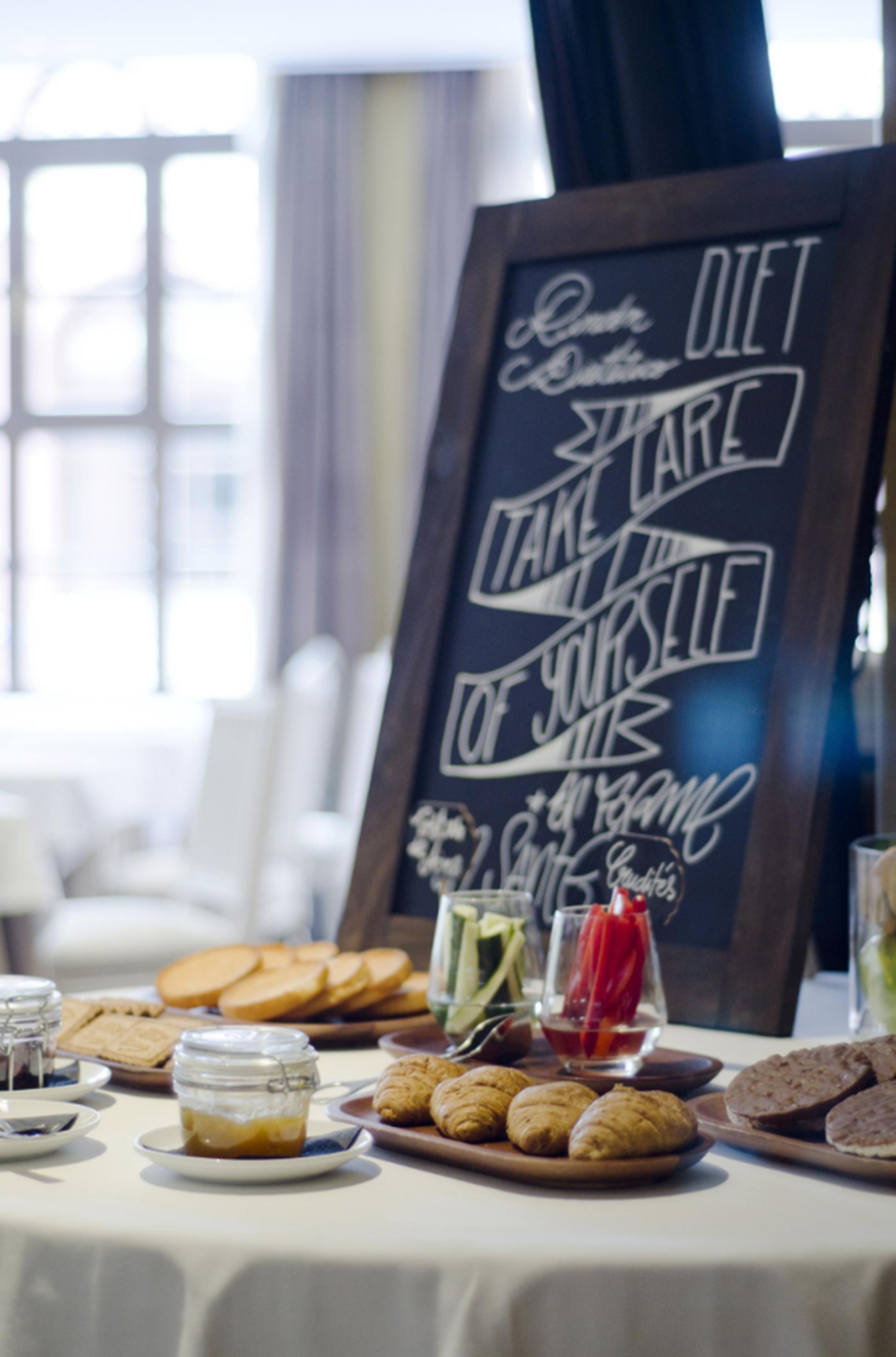 Una mesa con diversos alimentos y un cartel de pizarra con información nutricional.