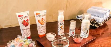 A wooden table with various skincare products, including tubes and bottles, arranged on a tray.
