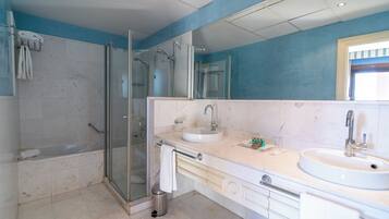 Uma casa de banho moderna com chuveiro em cabine de vidro, um espelho grande, uma pia e uma banheira.