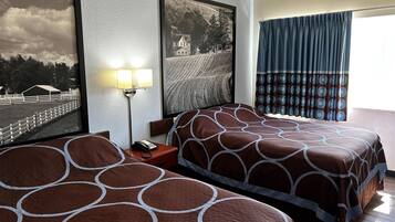 Een hotelkamer met twee bedden, een nachtkastje met een lamp, een inlijsting afbeelding aan de muur en een raam met gordijnen.
