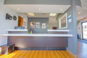 A reception desk with a computer, a clock, and informational posters on the wall. - Studio Inn Extended Stay Oklahoma City Airport by OYO (Oklahoma City)