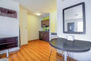 A small kitchenette with a microwave, cabinets, and a sink. There is a round table with two chairs and a mirror on the wall. - Studio Inn Extended Stay Oklahoma City Airport by OYO (Oklahoma City)