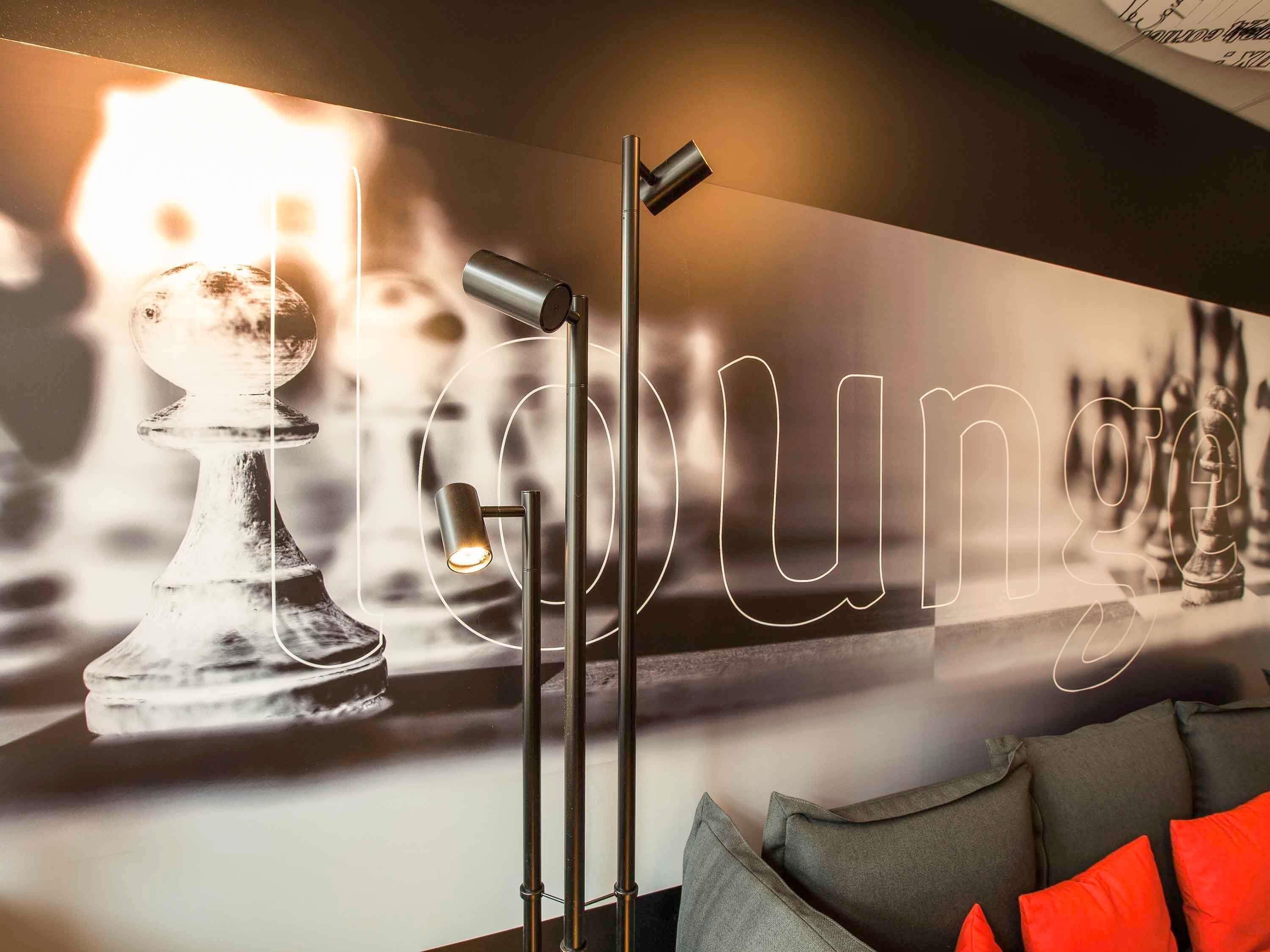 A chessboard with a modern light fixture in the foreground.