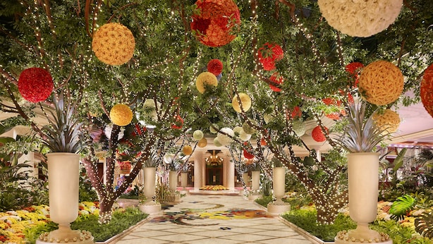 A grand hallway with a floral archway, potted plants, and a patterned floor. - Wynn Las Vegas (Las Vegas)
