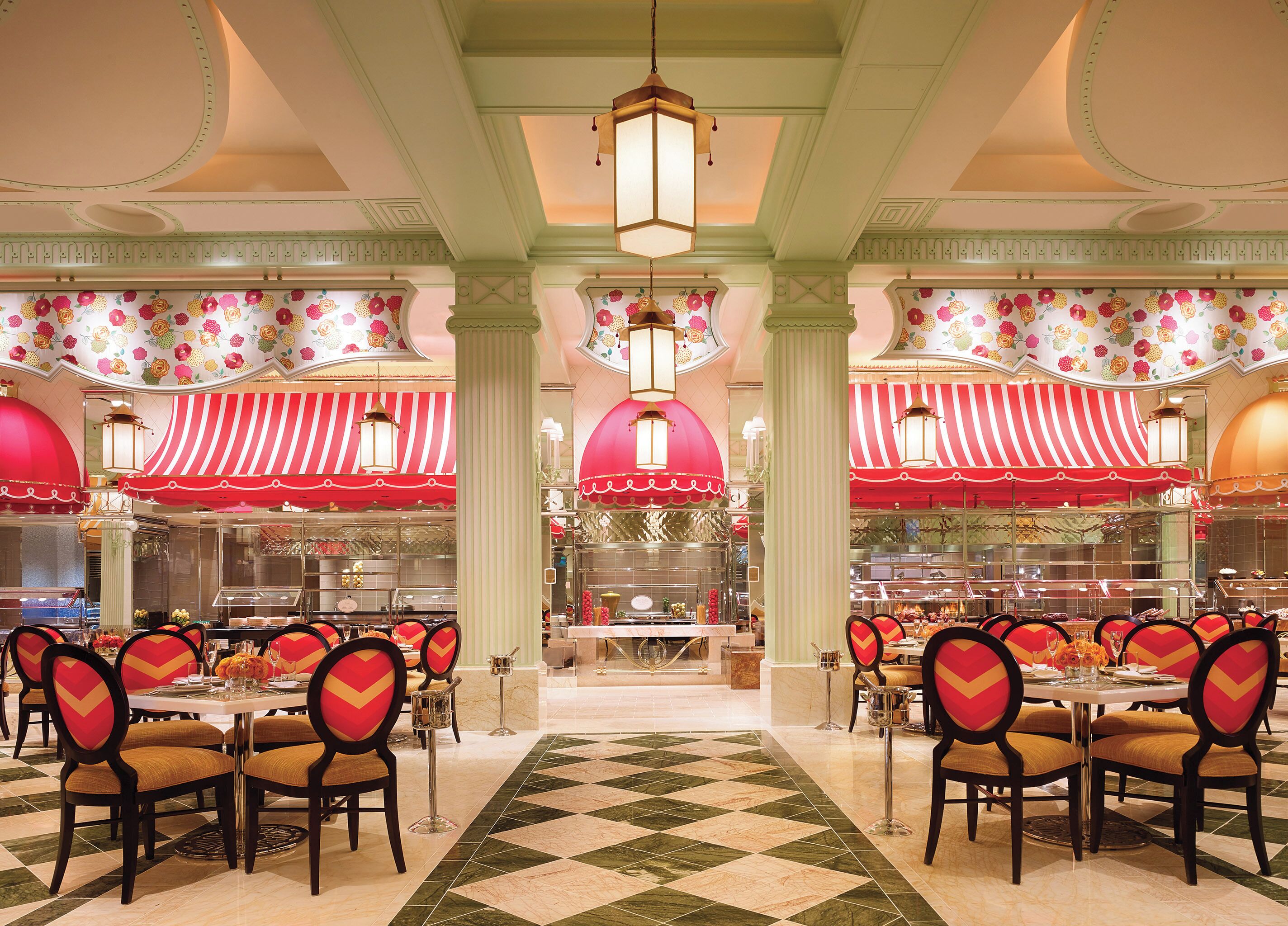 A dining area with striped awnings, a checkered floor, and a central chandelier.