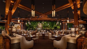 A spacious restaurant with high wooden beams, multiple tables and chairs, and a central decorative fountain. - Wynn Las Vegas (Las Vegas)