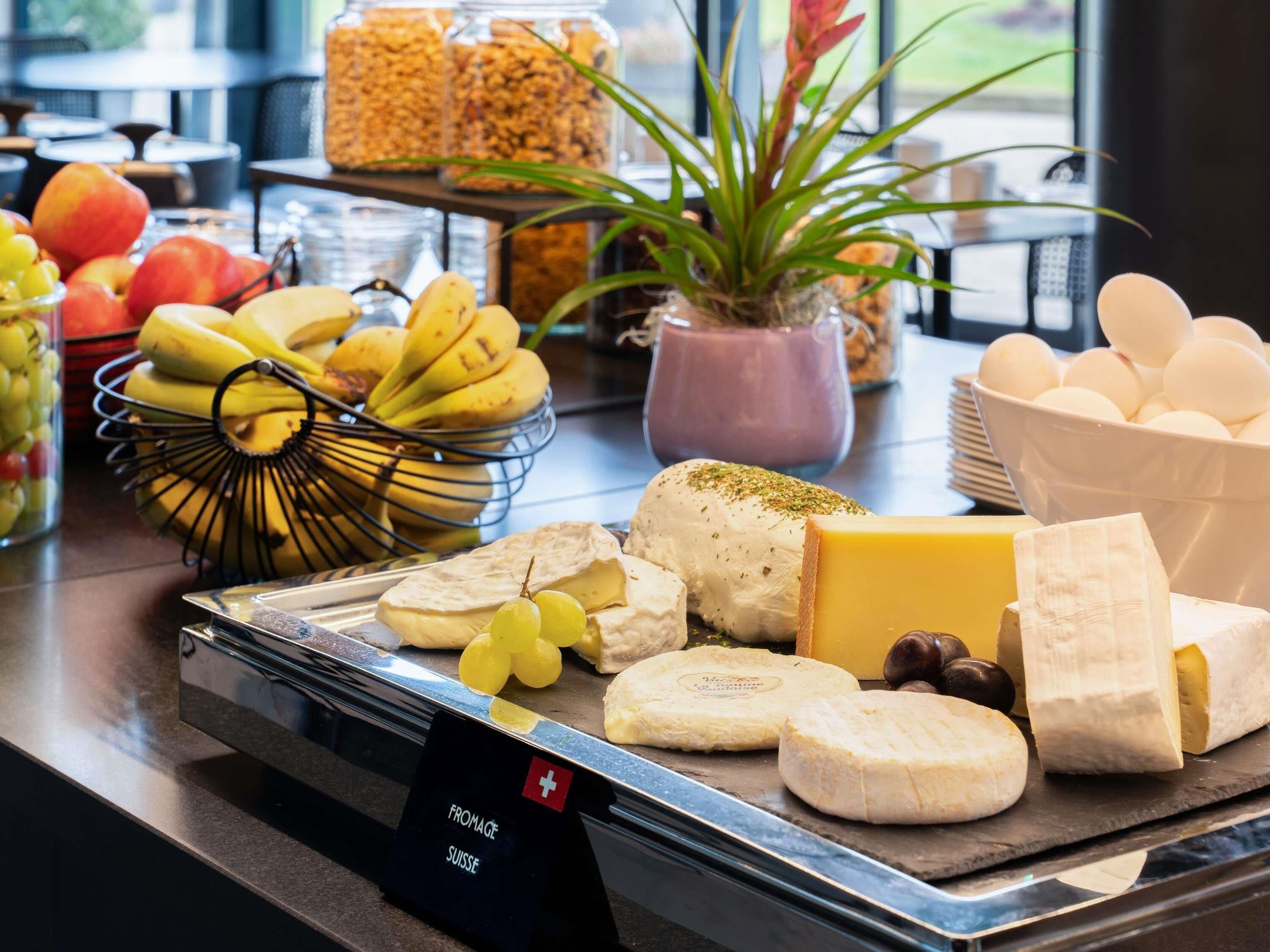 A cheese and fruit display with a sign indicating Swiss origin.