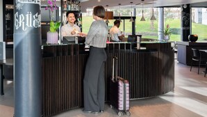 Una recepción con diseño moderno, una zona de bar con botellas y vistas al exterior.