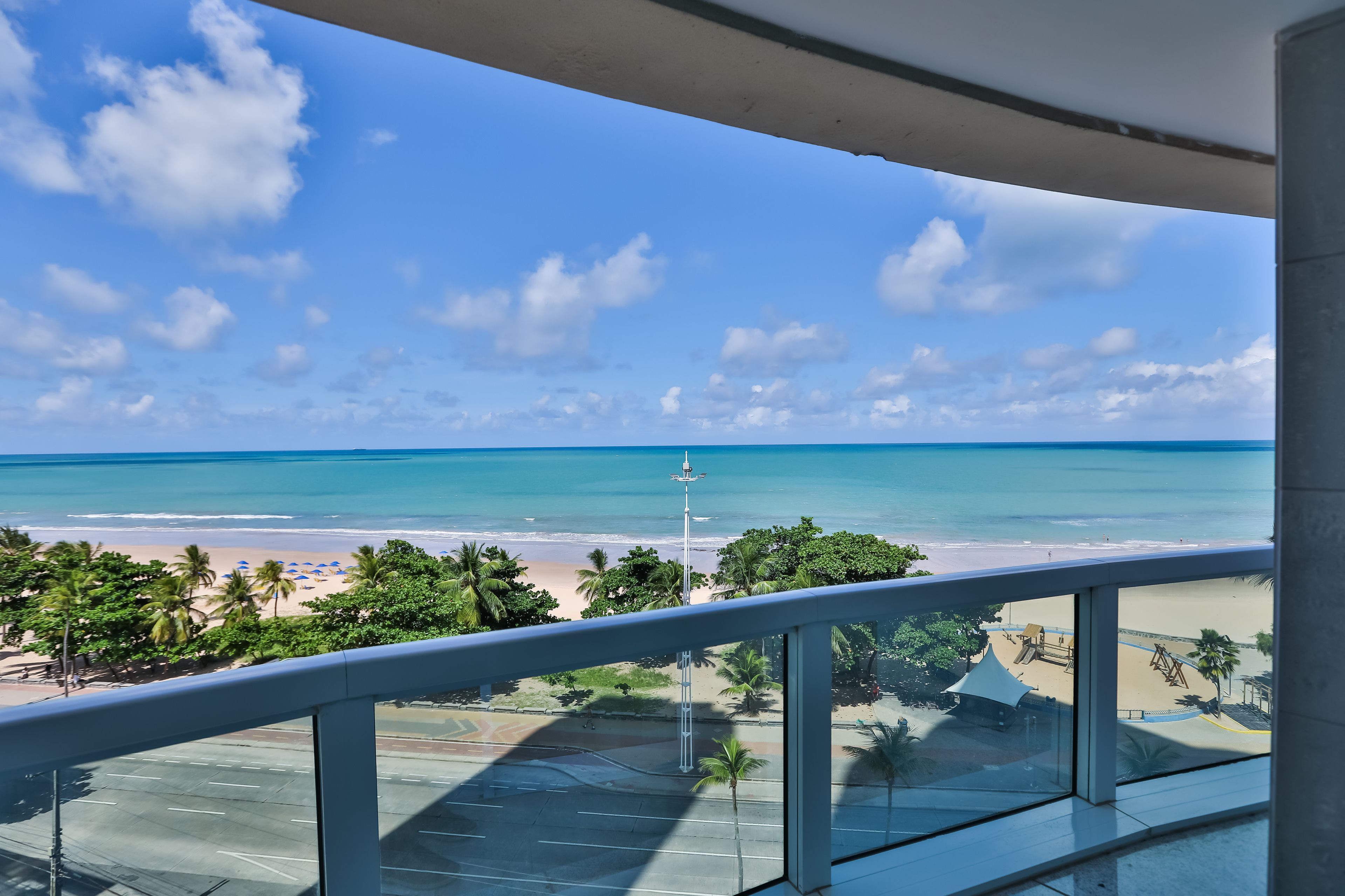 Un balcon avec vue sur une plage et l’océan.