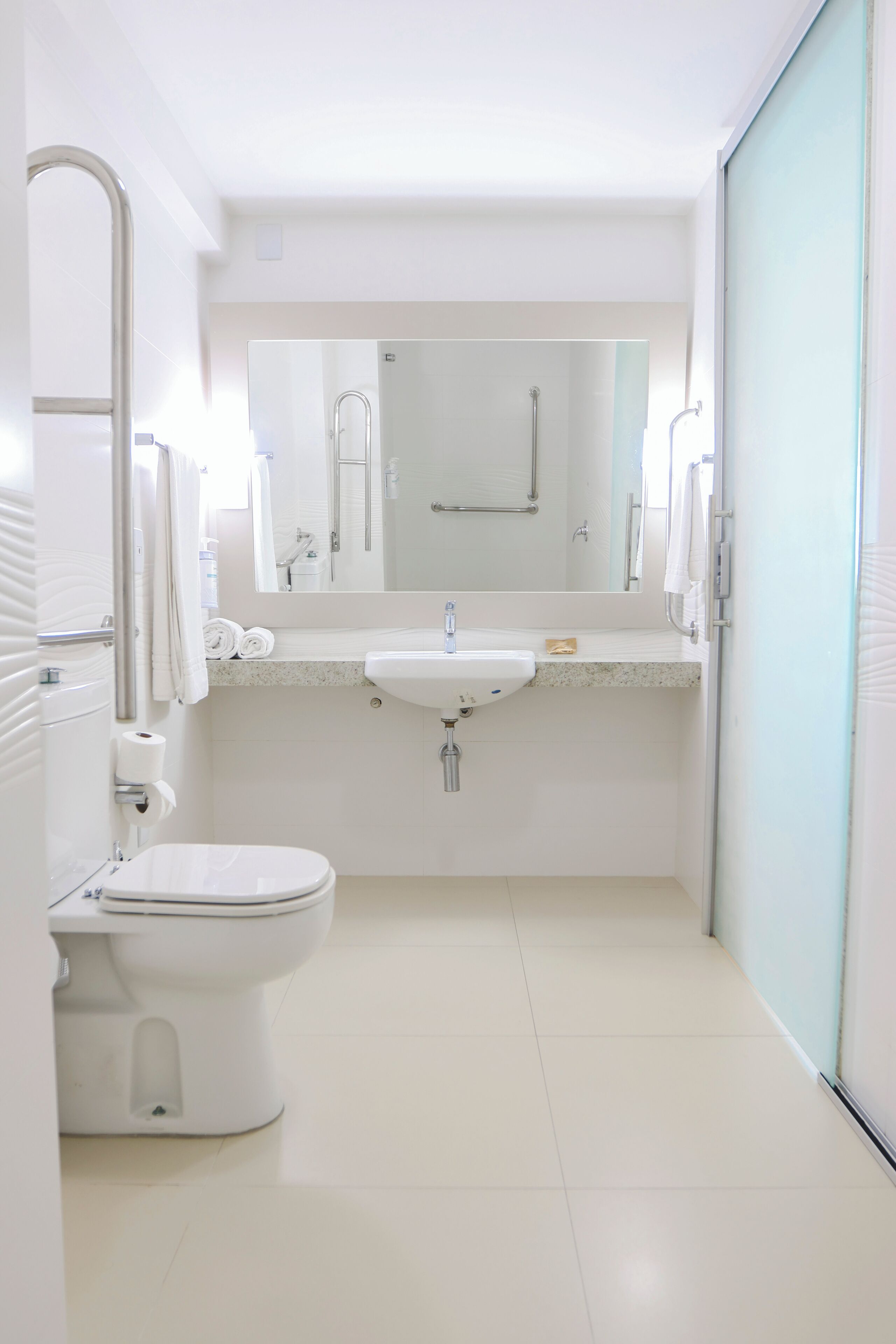 Un baño pequeño y limpio, con inodoro, lavamanos y espejo.