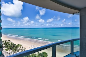 Un balcon avec vue sur une plage et l’océan.
