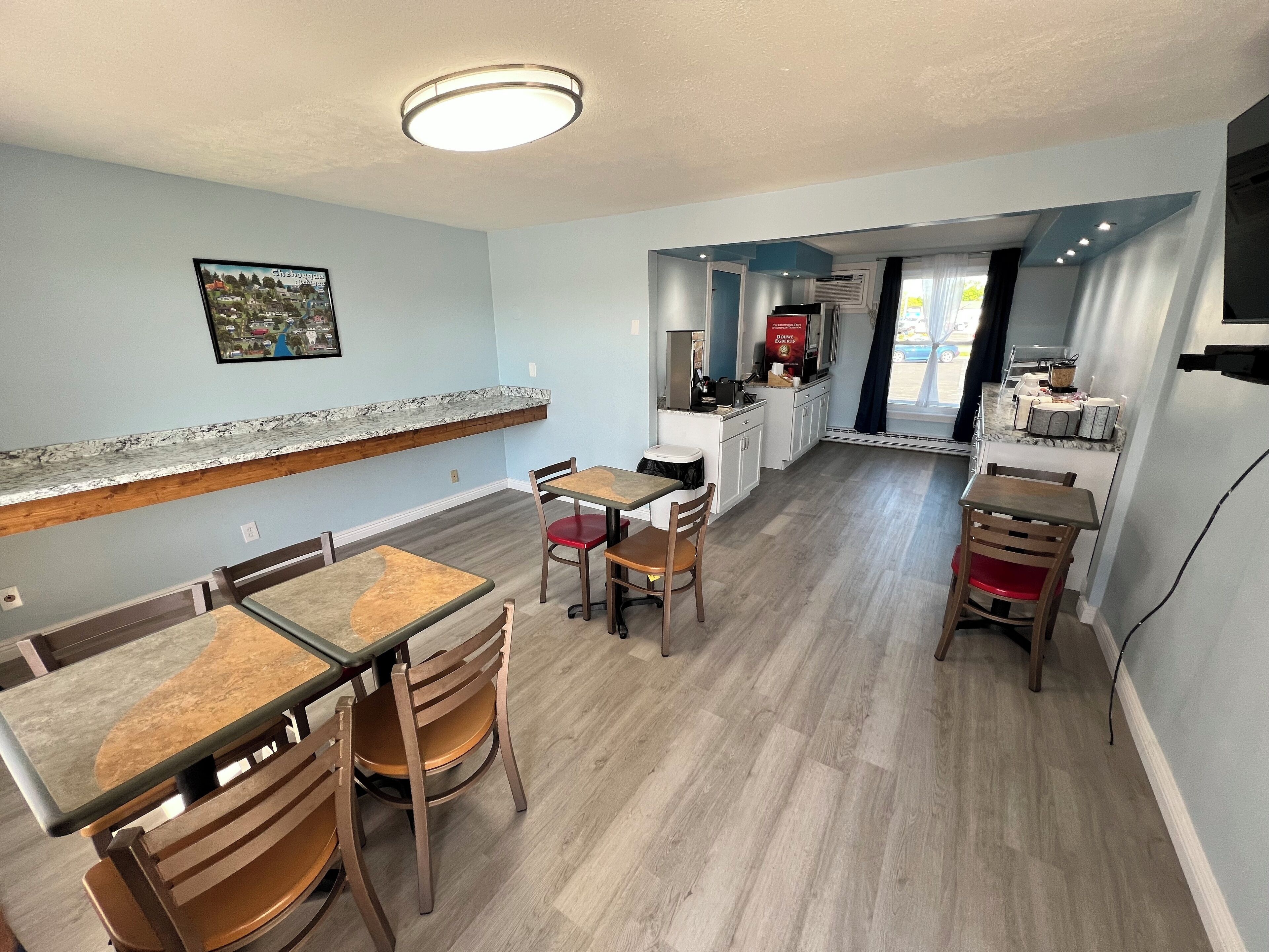 A modern kitchen with white cabinets, a marble countertop, and a built-in oven.
