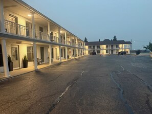Un motel doté de plusieurs balcons, d’un parking et d’un panneau indiquant l’emplacement de la salle de petit-déjeuner.