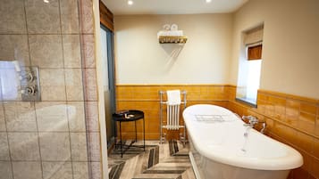 A bathroom with a bathtub, a towel rack, and a small table.