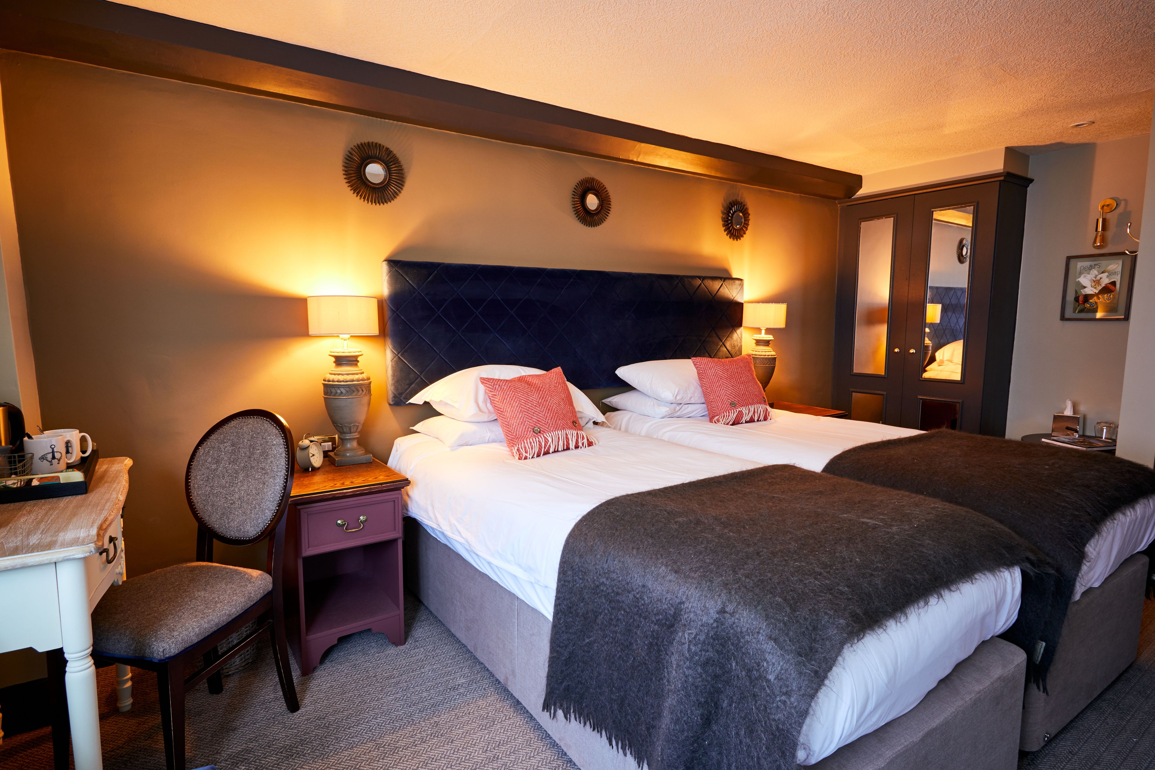 Une chambre d’hôtel avec un grand lit, deux tables de chevet, une chaise et un bureau.