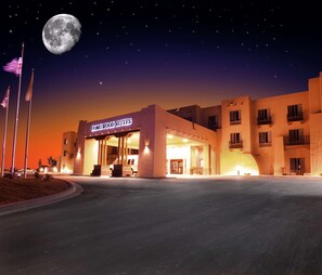 Un hôtel avec une enseigne indiquant « Homewood Suites », photographié de nuit, avec une grande lune dans le ciel.
