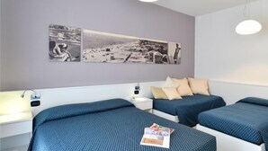 A hotel room with two beds, a nightstand, a wall-mounted light fixture, and a large photo collage on the wall. - Residence Progresso (Jesolo)