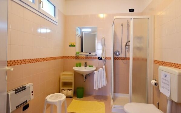 A small bathroom with a toilet, sink, and shower. - Residence Progresso (Jesolo)