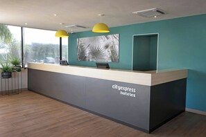 Una recepción con diseño moderno, un amplio ventanal y una planta en maceta.