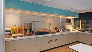 A modern kitchen with a breakfast bar, microwave, and various food items. - City Express by Marriott Reynosa (Reynosa)