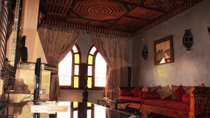 A room with a wooden ceiling, a red sofa, and a large mirror. - Kasbah Le Mirage (Marrakech)