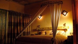 A room with a bed, curtains, a canopy, and two wall-mounted lights. - Kasbah Le Mirage (Marrakech)