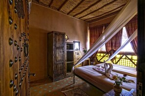 A bedroom with a bed, a wooden wardrobe, and a window with curtains. - Kasbah Le Mirage (Marrakech)