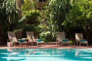 Utomhuspool, parasoller och solstolar