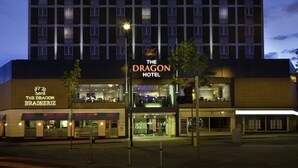 Hotel com placa indicando "The Dragon Hotel" e restaurante chamado "The Dragon Brasserie" na frente.