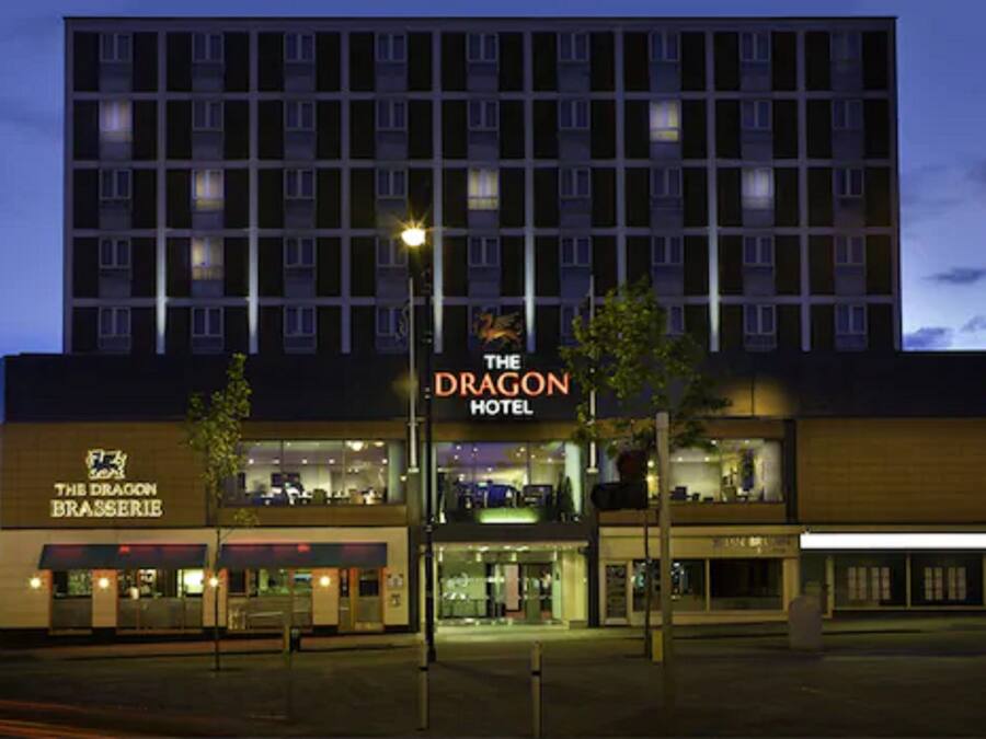 A hotel with a sign for "The Dragon Hotel" and a restaurant named "The Dragon Brasserie" in front.