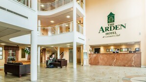 A spacious lobby with a reception desk, a seating area, and a staircase leading to an upper level. - The Arden Hotel & Leisure Club (Solihull)