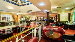 A spacious lobby with multiple seating areas, a staircase, and a high ceiling with skylights. - The Arden Hotel & Leisure Club (Solihull)