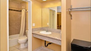 A bathroom with a toilet, sink, and shower. - The Emerald Inn on Sunset (Los Angeles)