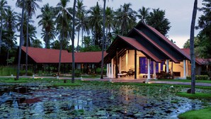 A resort with a large building, a pond with lily pads, and tall palm trees. - Wyndham Hua Hin Pranburi Resort & Villas (Pranburi)