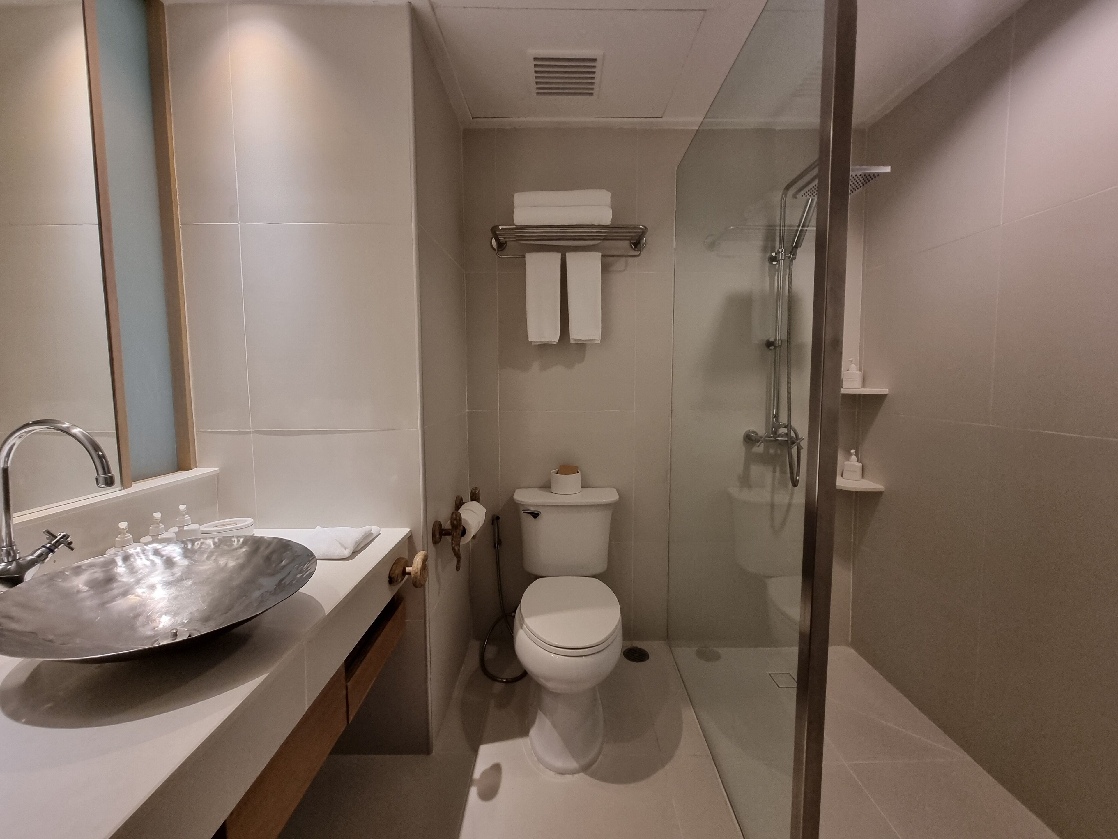 Un baño moderno con lavamanos grande, inodoro y ducha.