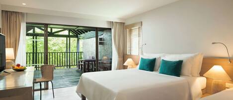 A hotel room with a large bed, a desk with a lamp, a chair, and a view of the outdoors.