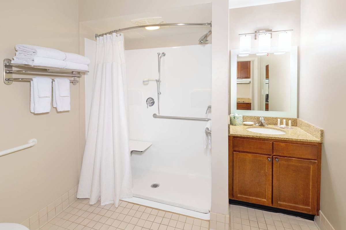 A bathroom with a shower, toilet, and sink.