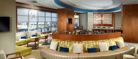A spacious lobby with a curved seating area, a reception desk, and large windows offering a view.