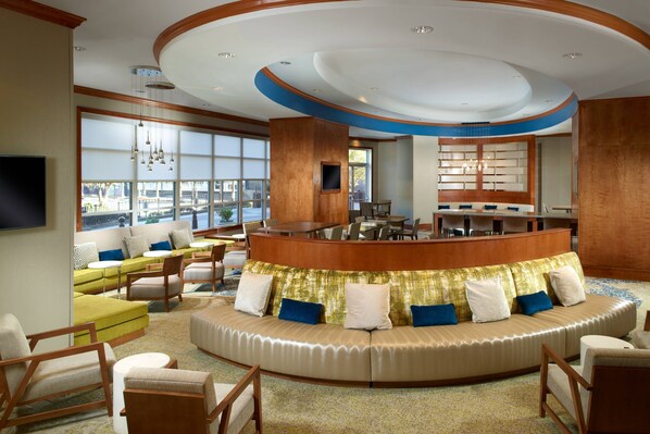 A spacious lobby with a curved seating area, a reception desk, and large windows offering a view. - SpringHill Suites by Marriott Atlanta Buckhead (Atlanta)