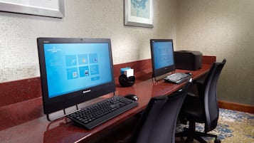 Een receptiebalie van een hotel met twee Lenovo computers, een toetsenbord en een muis.